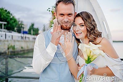 happy newlyweds exchange rings. beautiful wedding ceremony by water on dock. Stock Photo