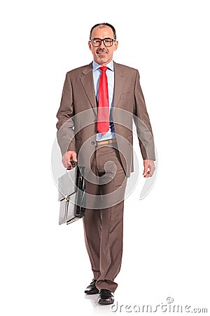 Happy old businessman with briefcase walking forward Stock Photo