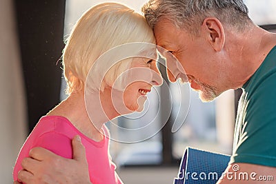 Happy old couple with yoga mat touching foreheads Stock Photo