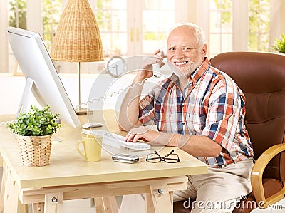 Happy old man on landline call Stock Photo