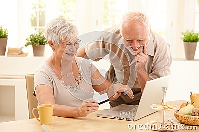 Happy older couple doing online shopping Stock Photo