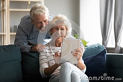 Happy older couple using computer tablet together at home Stock Photo