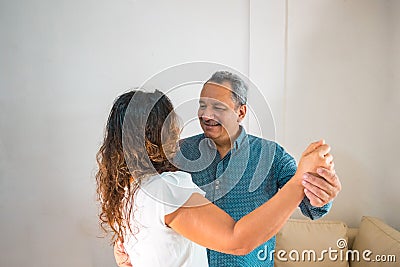 A happy older Hispanic couple having a good time at home. Elderly retirement and the concept of healthy elderly citizens Stock Photo