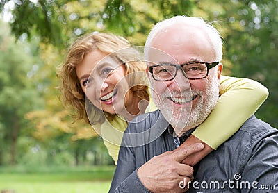 Happy older woman embracing smiling older man Stock Photo