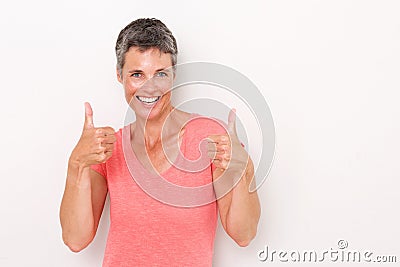 Happy older woman with thumbs up against white background Stock Photo
