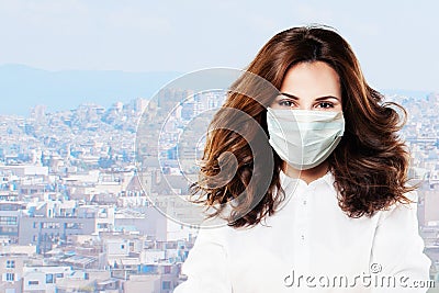 Happy optimistic doctor woman in a face mask on sity background outdoor Stock Photo