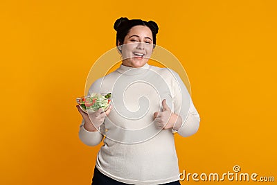 Happy Overweight Girl Holding Bowl With Salad And Showing Thumb Up Stock Photo