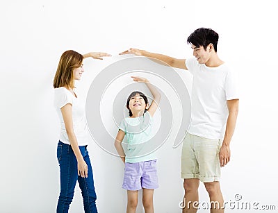 Happy parent measures the growth of daughter Stock Photo