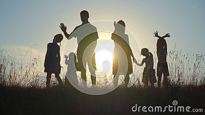 Happy parents with children waving hands at sunset. Stock Photo