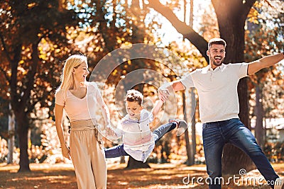 Parents have fun with their son in autumn park Stock Photo