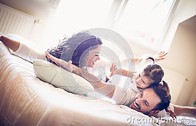 Happy parents have play with their little girl. Stock Photo