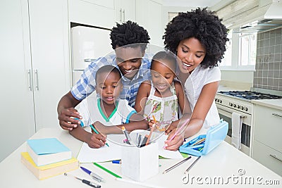 Happy parents helping children with homework Stock Photo