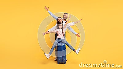 Happy Parents And Little Daughter Posing With Travel Suitcase, Studio Stock Photo