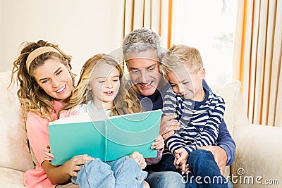 Happy parents reading to their kids Stock Photo