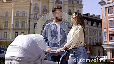Happy parents walking with newborn baby in carriage, family love and care Stock Photo