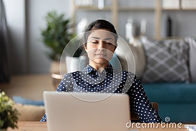 Happy peaceful millennial indian girl leaning on chair, resting. Stock Photo
