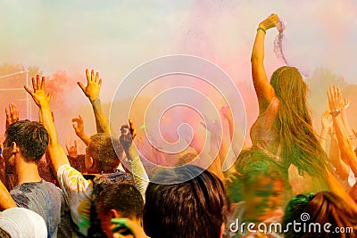 Happy people crowd partying under colorful powder cloud at holi Editorial Stock Photo