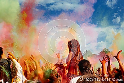 Happy people crowd partying under colorful powder cloud at holi Editorial Stock Photo