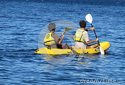 Happy people swimming in kayaks wearing lifejackets with paddle Editorial Stock Photo