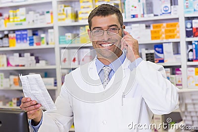 Happy pharmacist on the phone looking at the camera Stock Photo