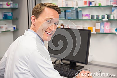 Happy pharmacist using the computer Stock Photo