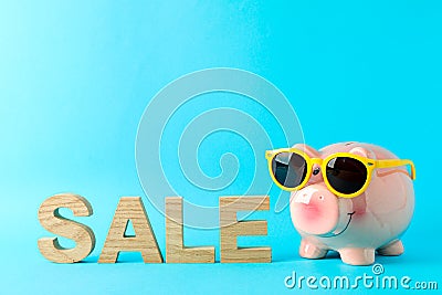 Happy piggy bank with sunglasses and inscription SALE on color background, space for text Stock Photo