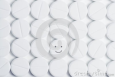 Happy pill surrounded by white prescription pills Stock Photo