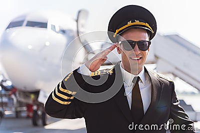 Cheerful smiling aviator standing outside Stock Photo