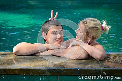 Happy playful couple relaxing in a swimming pool Stock Photo