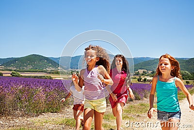 Happy playmates running through lavender field Stock Photo