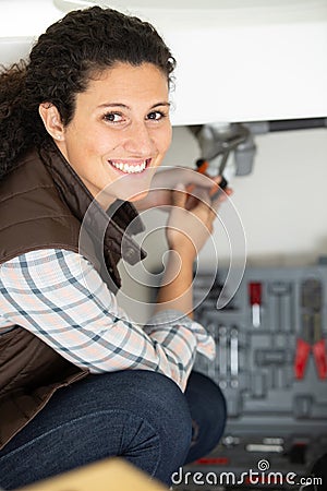 happy plumber woman installing pipes Stock Photo