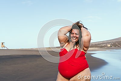 Happy plus size woman posing on the beach - Curvy overweight model having fun during vacation in tropical destination Stock Photo
