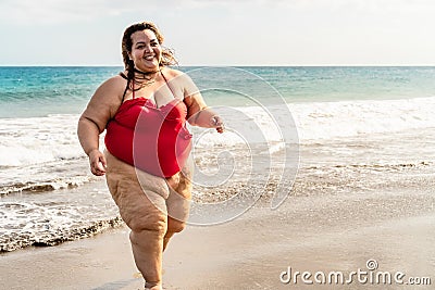 Happy plus size woman running on the beach - Curvy overweight model having fun during vacation in tropical destination Stock Photo