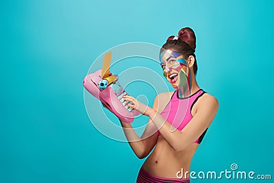 Happy pop art model smiling, holding toy typewriter. Stock Photo