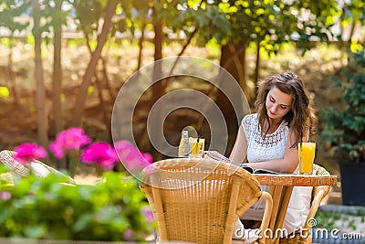 Happy, positive, beautiful, elegance girl sitting at cafe table outdoors. Stock Photo