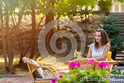 Happy, positive, beautiful, elegance girl sitting at cafe table outdoors. Stock Photo