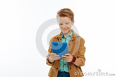 Happy positive young boy holding his tablet Stock Photo