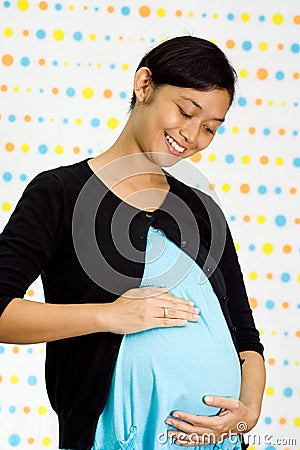 Happy pregnant asian ethnic woman Stock Photo