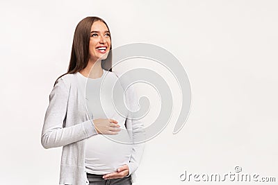 Happy Pregnant Lady Touching Belly Standing, Studio Shot Stock Photo