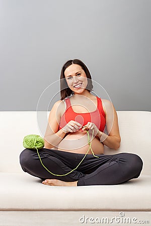 Happy pregnant woman is crocheting Stock Photo
