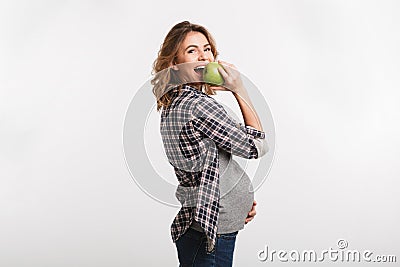 happy pregnant woman eating apple and smiling at camera Stock Photo