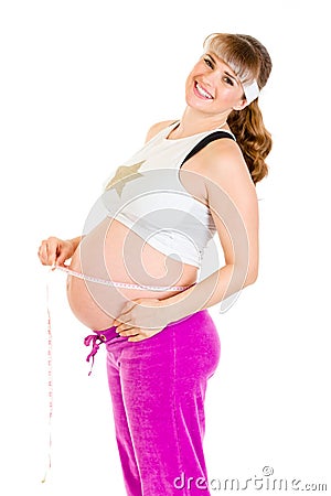 Happy pregnant woman measuring her belly Stock Photo