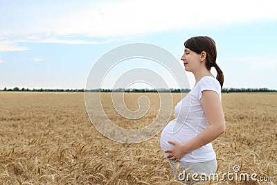 Happy pregnant woman in the summer field Stock Photo