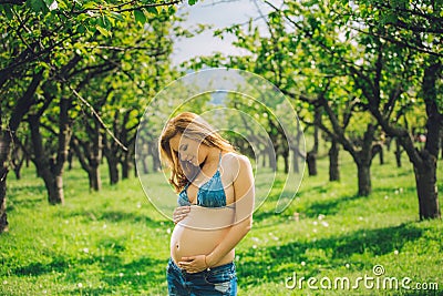 Happy pregnant woman in swimwaer and jeans in harmony with the nature Stock Photo