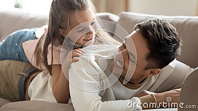 Daughter lies on daddy back family play together relaxing indoor Stock Photo