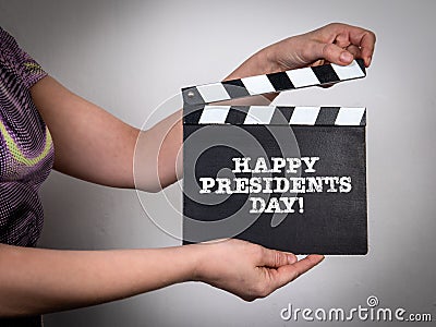 Happy Presidents Day. Woman in a colored dress holding a film clapper Stock Photo