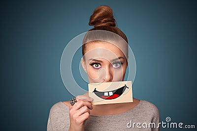 Happy pretty woman holding card with funny smiley Stock Photo