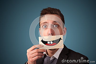 Happy pretty woman holding card with funny smiley Stock Photo