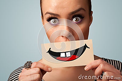 Happy pretty woman holding card with funny smiley Stock Photo