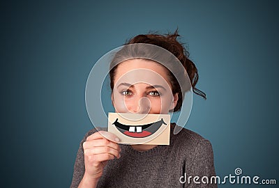 Happy pretty woman holding card with funny smiley Stock Photo